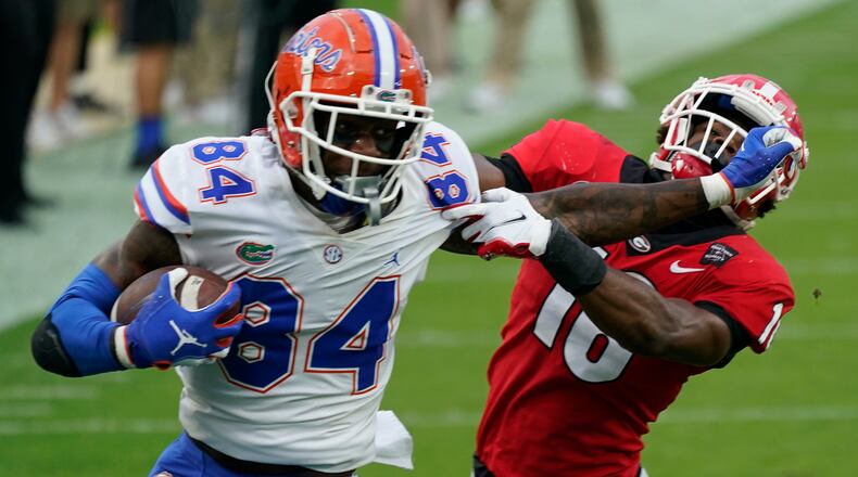 Florida tight end Kyle Pitts (84) tires to get past Georgia defensive back Lewis Cine (16) after a reception during the first half Saturday, Nov. 7, 2020, in Jacksonville, Fla.  (John Raoux/AP)