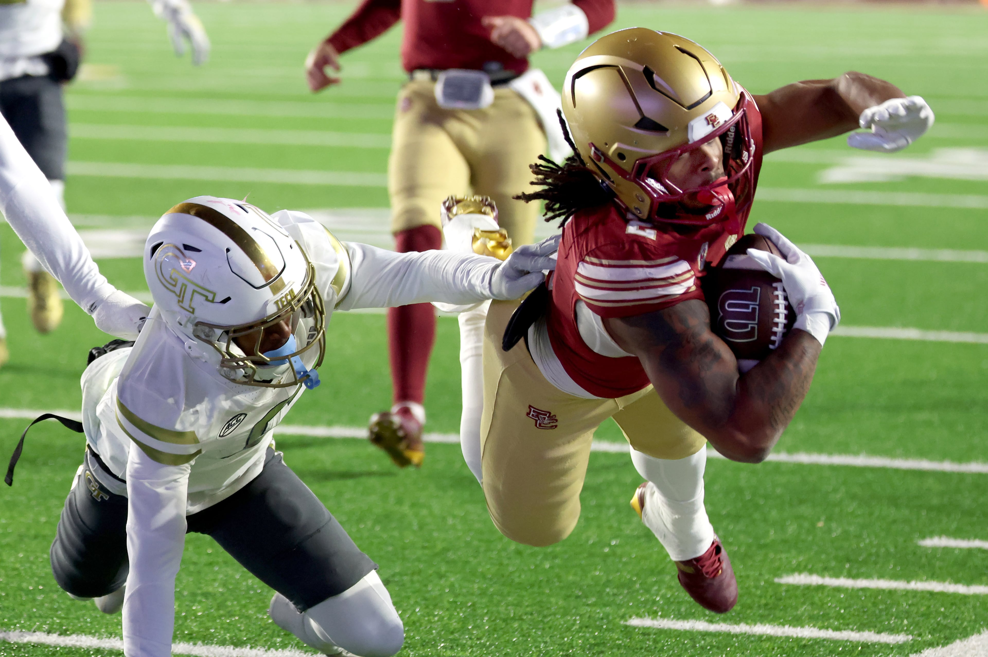 Boston College running back Turbo Richard, right, carries the ball to the sideline while chased by Georgia Tech defensive back Rodney Shelley, left, during the second half of an NCAA college football game Saturday, Nov. 15, 2025, in Boston. (AP Photo/Mark Stockwell)
