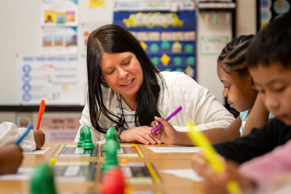 Vickery Mill Elementary School literacy coach Jinny Benson helps first grade students work on phonics on Thursday, March 5, 2026. The House recently passed a budget that includes $31 million to hire literacy coaches. (Ben Hendren for the AJC)