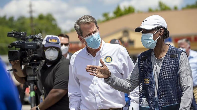 Georgia Gov. Brian Kemp receives information about a community COVID-19 testing site from Public Health District 2 Director, Dr. Pamela Logan (right), in the parking lot of La Flor de Jalisco #2 during a visit to Gainesville.