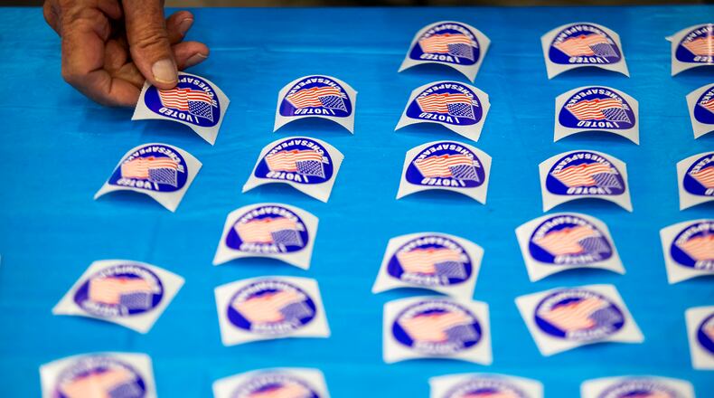 A poll worker lays out "I voted" stickers at Chesapeake Central Library on Nov. 8, 2022. (Kendall Warner/The Virginian-Pilot/TNS)