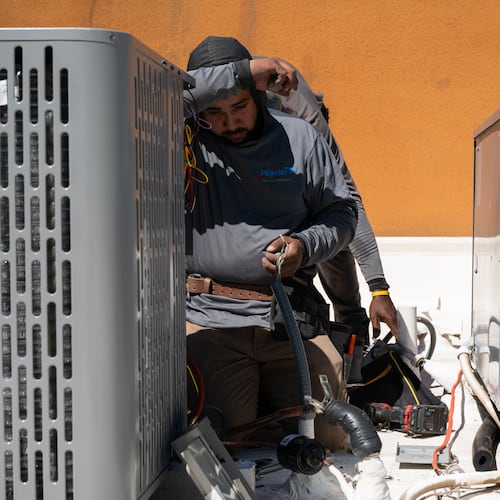 Brian Hermosillo wipes sweat from his brow while installing a new air conditioning unit during record-breaking heat Thursday, March 19, 2026, in Tempe, Ariz. (AP Photo/Caitlin O'Hara)