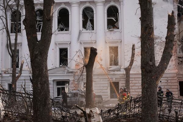 A rescue worker puts out a fire from a tree after a Russian missile strike on Sumy, Ukraine, Sunday, April 13, 2025. (AP Photo/Volodymyr Hordiienko)