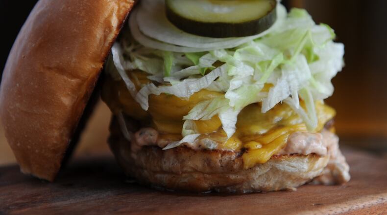 131017-ATLANTA-GA- Jon Watson's dine review of Illegal Food on Thursday October 17, 2013. FOOD: The Hank -(double patty version) beef burger, crisp iceberg, American cheese, fridge pickle, sweet onion, special sauce and topped with H&F bun. (BECKY STEIN)