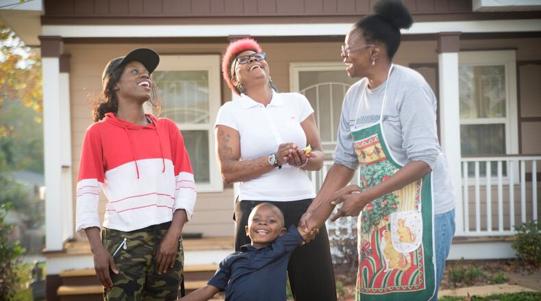 Atlanta Habitat homeowner Jamilah Najeeullah (right) shares a laugh with her daughter, granddaughter and great-grandson in front of her new home. This will be Najeeullah’s first Thanksgiving there. CONTRIBUTED