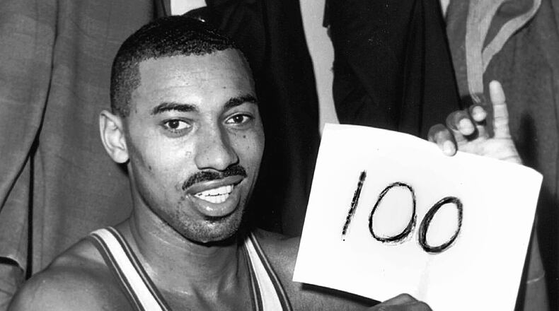 FILE - Philadelphia Warriors' Wilt Chamberlain holds a sign reading, "100," in the dressing room after he scored 100 points against the New York Knickerbockers, March 2, 1962, in Hershey, Pa. (AP Photo/Paul Vathis, File)