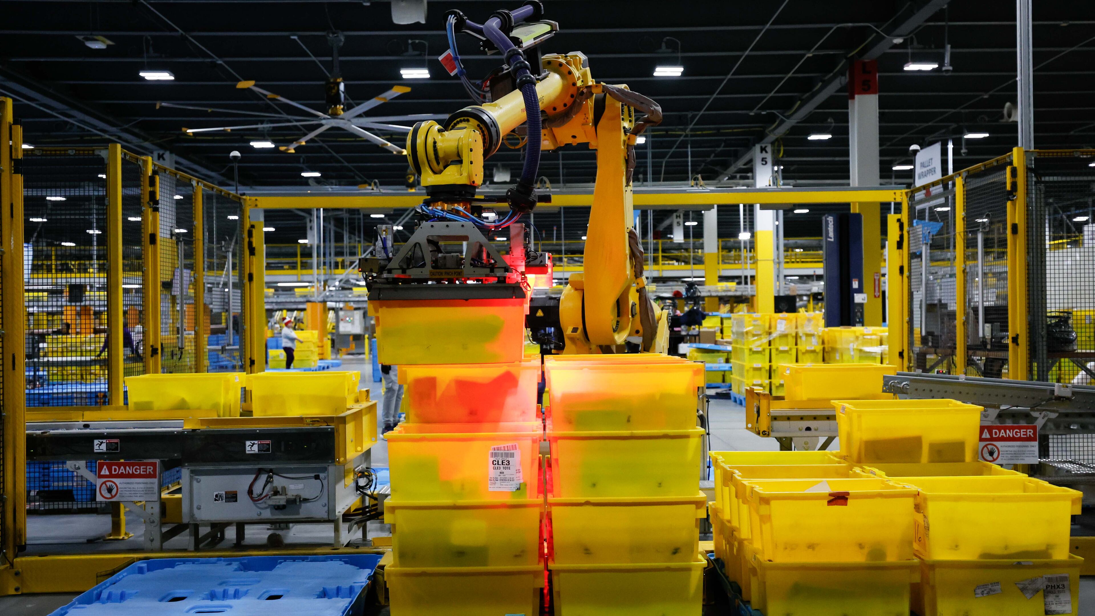 An automated arm robot is seen moving bins full of packages at the Transfer Out Station on Monday, Dec.2, 2024. The Amazon distribution center in Stone Mountain is preparing to fulfill thousands of orders for Cyber Monday. (Miguel Martinez/AJC)