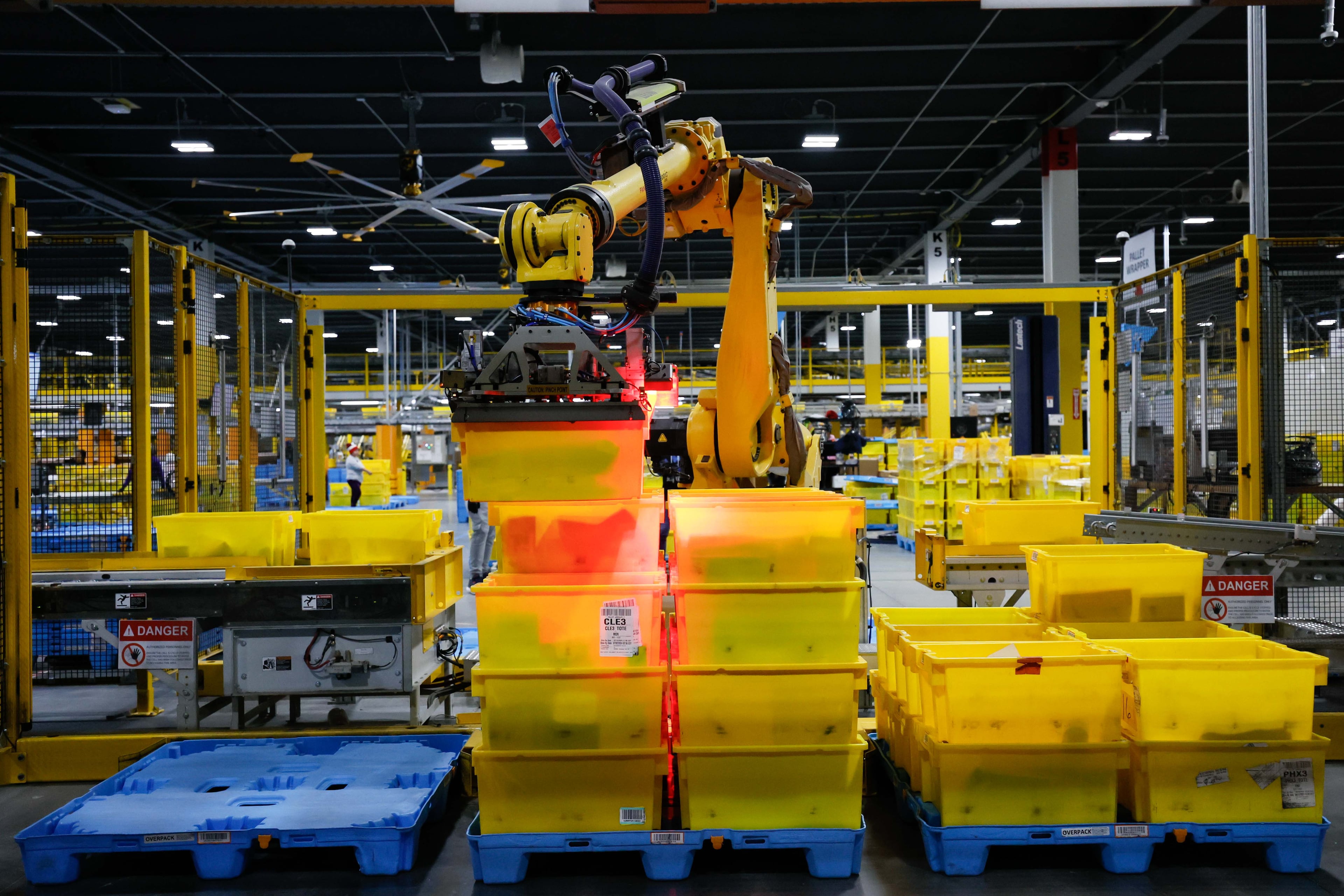 An automated arm robot is seen moving bins full of packages at the Transfer Out Station on Monday, Dec.2, 2024. The Amazon distribution center in Stone Mountain is preparing to fulfill thousands of orders for Cyber Monday. (Miguel Martinez/AJC)