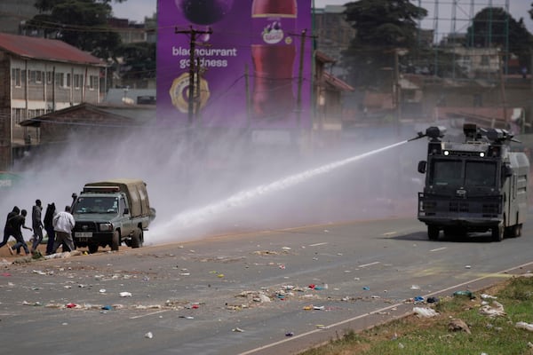 Riot police scatter protesters with water canons during the historic 1990 "Saba Saba", a Swahili word that means seven seven, protests for democratic reforms in the Kangemi slum of Nairobi, Kenya Monday, July 7, 2025. (AP Photo/Brian Inganga)