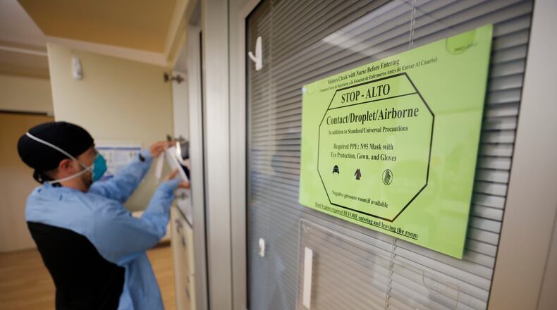 COVID-19 still poses a threat, especially to those who are medically vulnerable, including older adults. A sign advises medical personnel and visitors to take precautions before entering rooms with patients infected with COVID-19 at the Northeast Medical Georgia Center in Gainesville last February. (Miguel Martinez/The Atlanta Journal-Constitution/TNS)