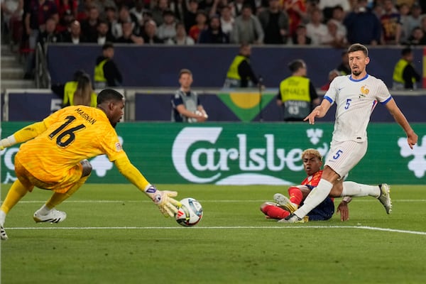Spain's Lamine Yamal scores by France's Clement Lenglet during the Nations League semifinal soccer match between Spain and France in Stuttgart, Germany, Thursday, June 5, 2025. (AP Photo/Matthias Schrader)