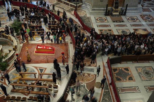 Faithful pay their respects to Pope Francis lying in state inside St. Peter's Basilica at the Vatican, Thursday, April 24, 2025. (AP Photo/Alessandra Tarantino)