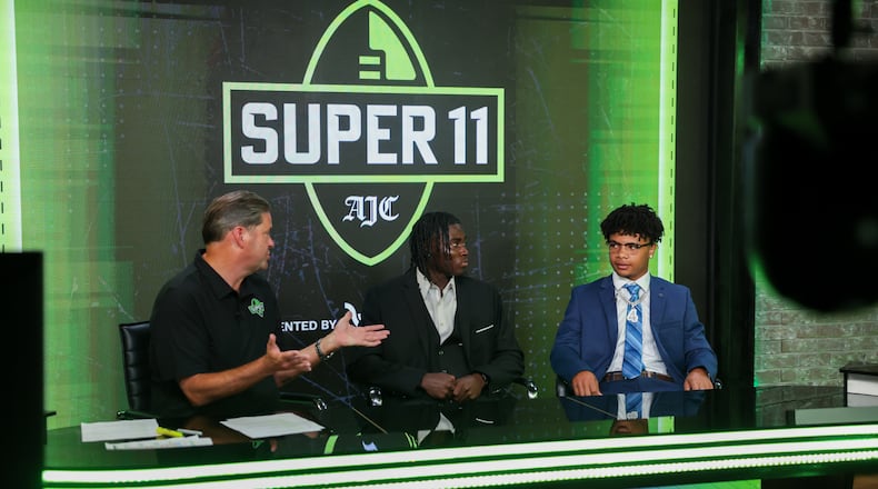 (L-R) DawgNation’s Brandon Adams interviews Creekside’s Gary Walker and Valdosta’s Marquis Fennell during the taping of the Super 11 reveal show at Score ATL in Roswell on Aug. 3, 2026. (Arvin Temkar/AJC)