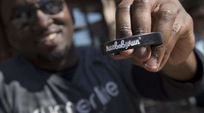 Sean Roberson holds one of his custom bracelets with his company’s name on it, before starting his run on May 22, 2015, through Piedmont Park in Atlanta. After Roberson donated one of his kidneys to his older brother, he started a running apparel line to help others live a healthier life. STEVE SCHAEFER / SPECIAL TO THE AJC