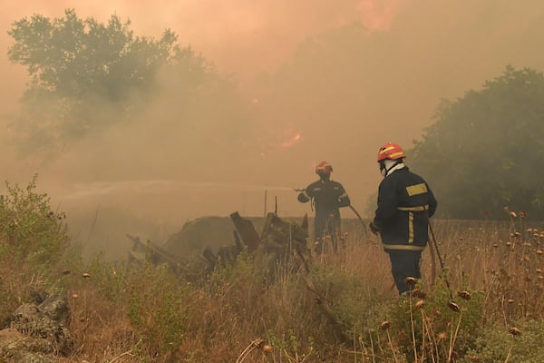 Firefighters try to extinguish a major forest fire in the village of Karteri, near Corinth, west of Athens, Greece, on Tuesday, July 22, 2025. (AP Photo/Vasilis Psomas)