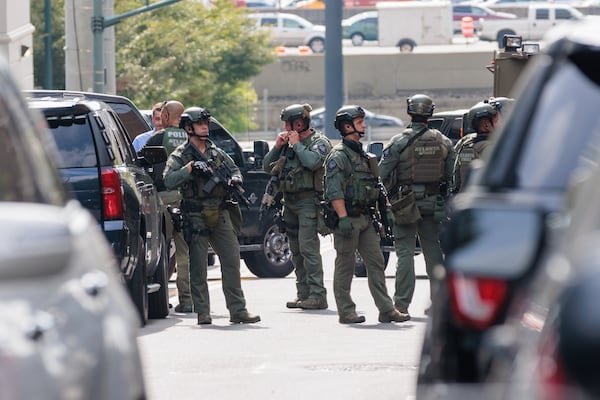 A SWAT team gathers outside a condominium building on 16th and Spring Street in Midtown Atlanta on Monday, August 22, 2022. Raissa Kengne is accused of shooting three men and holding a young woman at gunpoint. (Arvin Temkar/AJC)