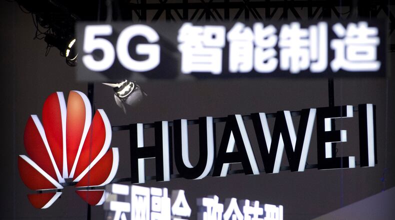 FILE - Signs promoting 5G wireless technology from Chinese technology firm Huawei are displayed at the PT Expo in Beijing on Sept. 26, 2018. (AP Photo/Mark Schiefelbein, File)