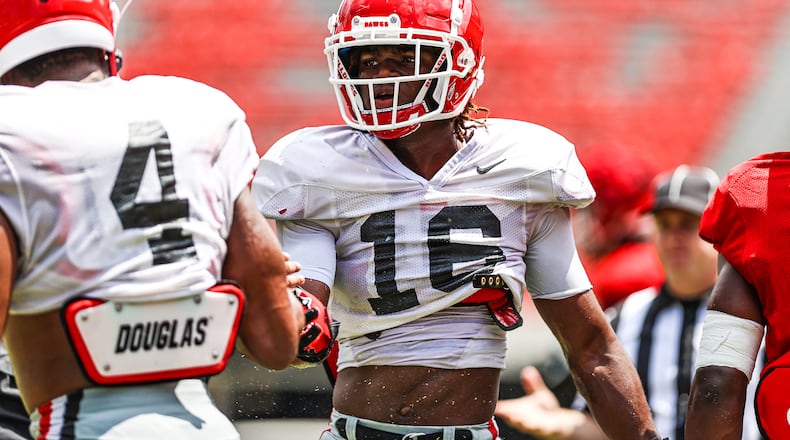 Georgia safety Lewis Cine (16), congratulates outside linebacker Nolan Smith after a play during the Bulldogs’ scrimmage on Dooley Field at Sanford Stadium this past Saturday (Photo by Tony Walsh/UGA Athletics)