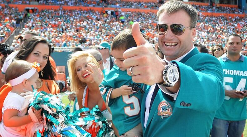 Former Miami Dolphins linebacker Zach Thomas gives a big thumbs up as he carries one of his children on the field prior to his induction into the Dolphins Ring of Honor during halftime of the game between the Dolphins and St. Louis Rams at Sun Life Stadium in Miami, Florida, Sunday, Oct. 14, 2012. (Robert Duyos/Sun Sentinel/TNS)