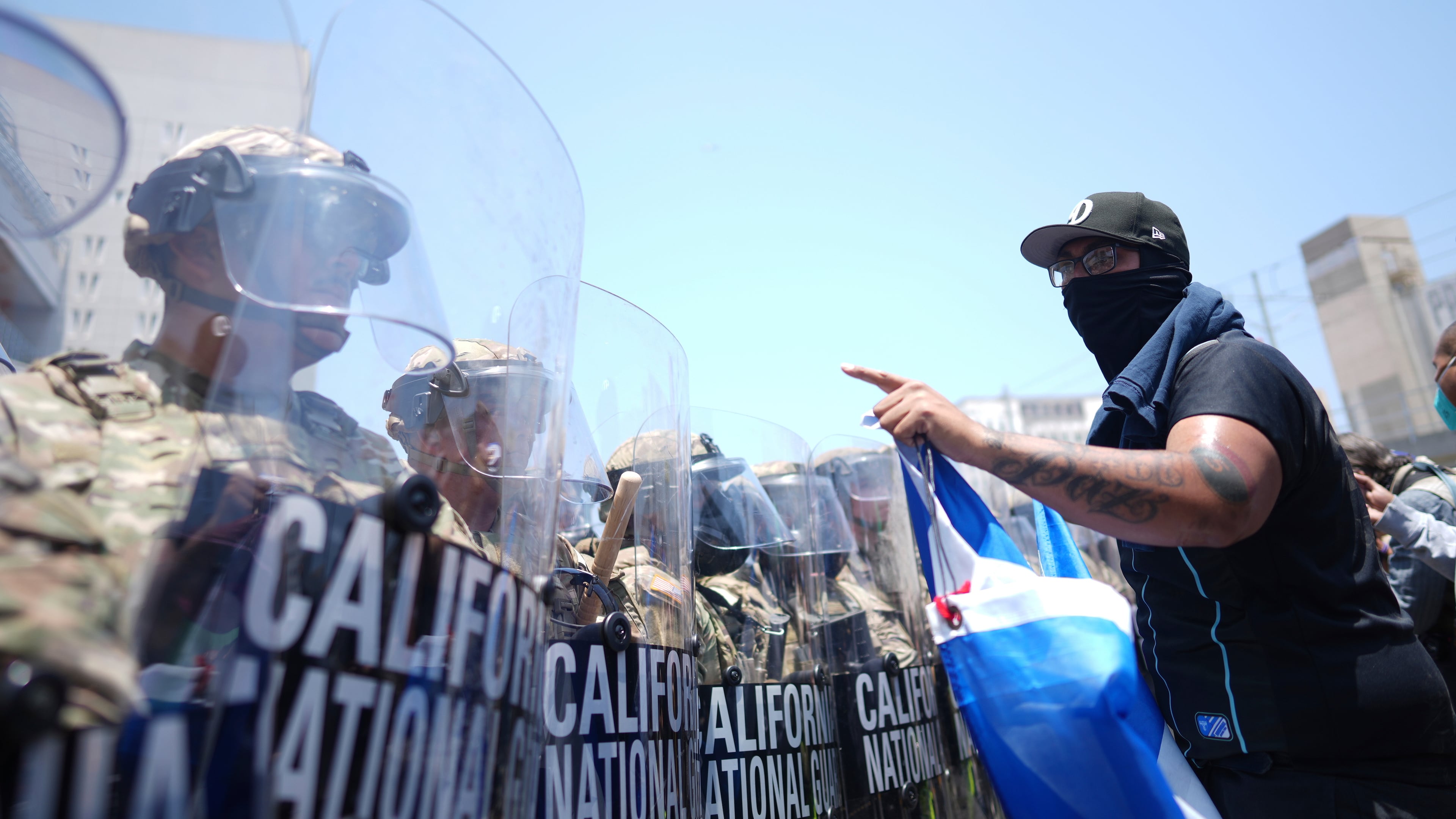 FILE - A protester confronts a line of U.S. National Guard in the metropolitan detention center of downtown Los Angeles, June 8, 2025, following last night's immigration raid protest. (AP Photo/Eric Thayer, File)