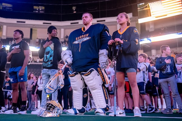 Georgia Swarm goalie Craig Wende and Karaline Apoian stand at attention during the National Anthem at a recent Swarm lacrosse game. Courtesy of Georgia Swarm