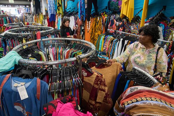 Business owner Asha Sham, originally from India, left, assists her wholesale client, fashion designer Diana Axtell from San Jose, purchasing African and Indian-made imported clothes at the "O.K. Mike" resort wear store in the Fashion District in Los Angeles, Thursday, April 3, 2025. (AP Photo/Damian Dovarganes)