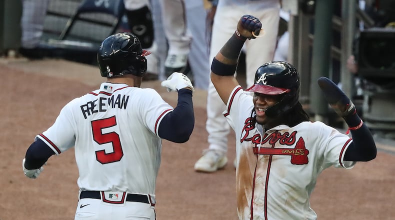 Freddie Freeman celebrates with Ronald Acuna during a Braves game last season at Truist Park. (Curtis Compton/ccompton@ajc.com)