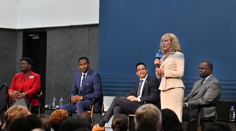 Mayoral candidate Sharon Gay speaks as other mayoral candidates (from left) Felicia Moore, Andre Dickens, Antonio Brown and Kasim Reed listen during a debate at The Gathering Spot last Thursday, October 7, 2021. (Hyosub Shin / Hyosub.Shin@ajc.com)