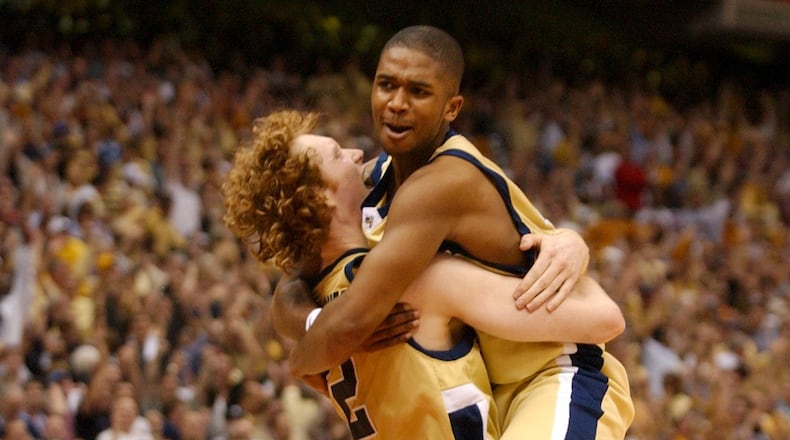 040403 - SAN ANTONIO, TX -- Georgia Tech's Luke Schenscher (cq, 12), center, hugs teammate Marvin Lewis (cq, 24), right-top, after defeating Oklahoma State at the 2004 NCAA Final Four at the Alamodome Saturday evening, April 3, 2004 . Georgia Tech won 67 to 65. (SUNNY SUNG/AJC staff)