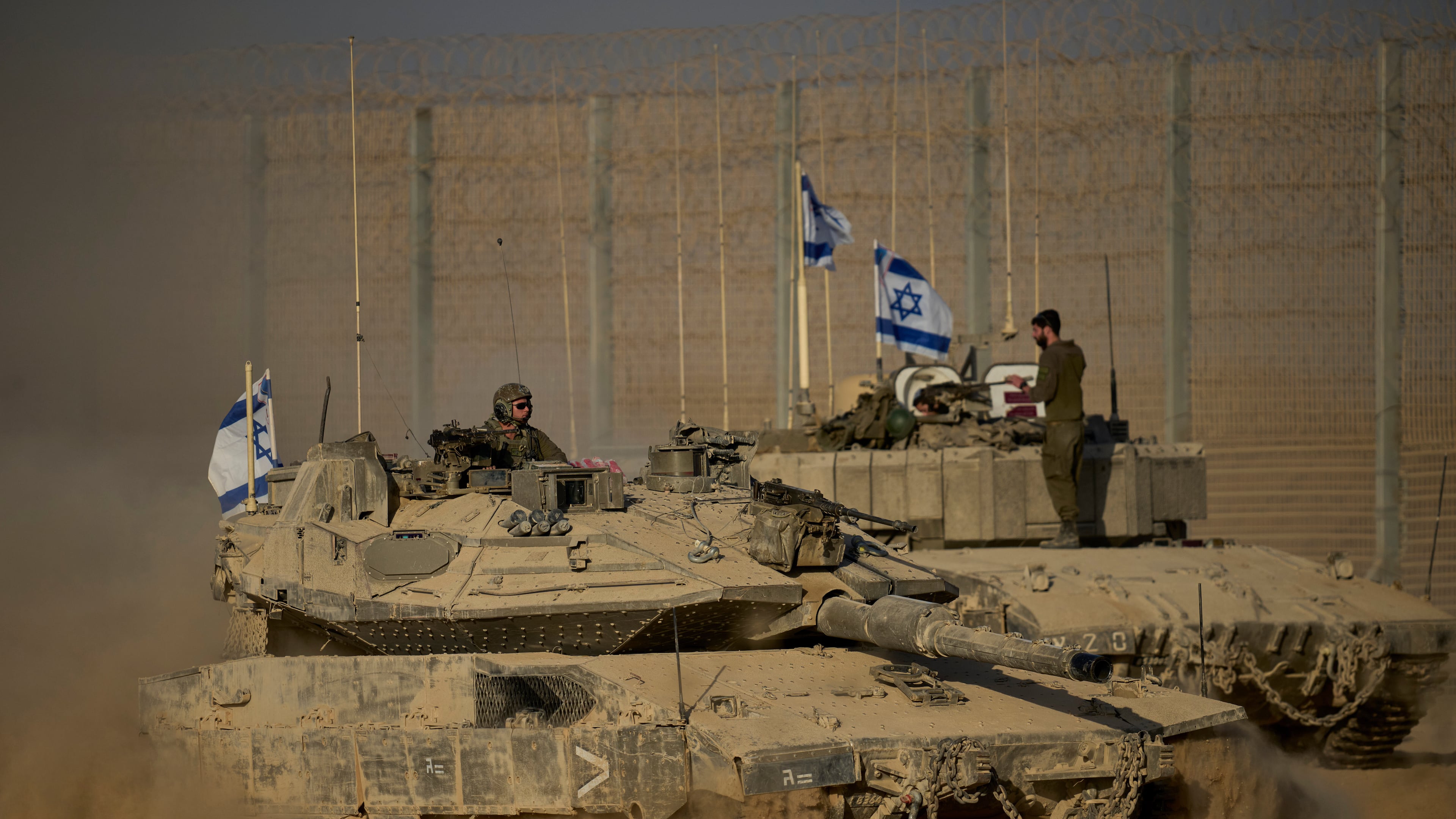 Israeli tanks move along the Israeli-Gaza border as seen from southern Israel, Monday, Oct. 20, 2025. (AP Photo/Ohad Zwigenberg)