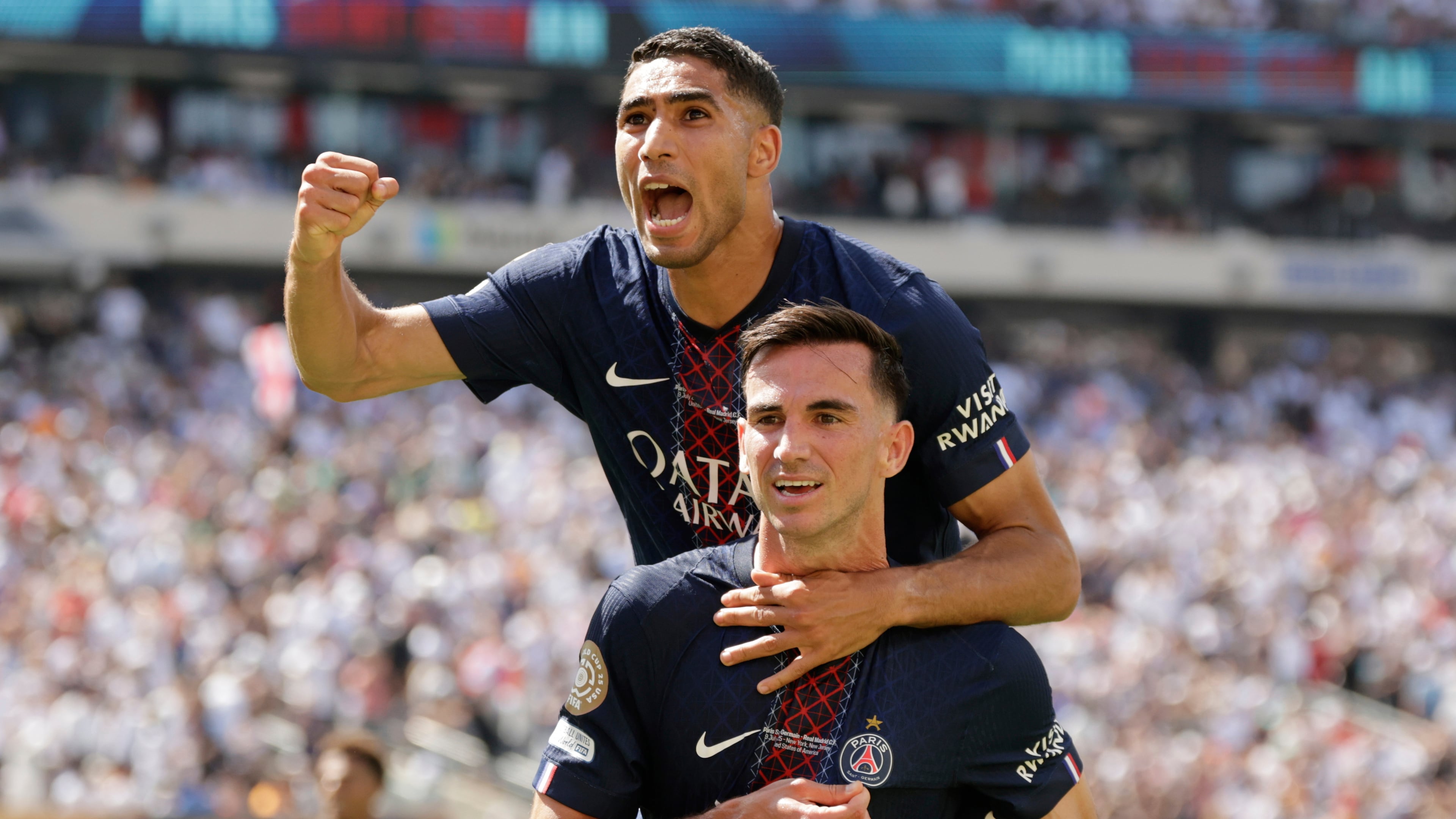 Paris Saint-Germain's Fabian Ruiz, bottom, celebrates with team mate Achraf Hakimi after scoring his side's third goal during the Club World Cup semifinal soccer match between PSG and Real Madrid in East Rutherford, N.J., Wednesday, July 9, 2025. (AP Photo/Adam Hunger)