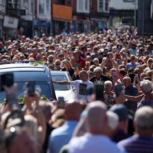Fans of singer Bonnie Tyler line the streets as her coffin is transported in a hearse back to her former home ahead of her funeral, in Mumbles, Wales, Saturday, Aug. 15, 2026. The Total Eclipse Of The Heart musician, whose real name was Gaynor Hopkins, died in hospital in Portugal on July 8 at the age of 75. (AP Photo/Alastair Grant)