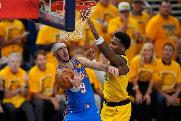 Oklahoma City Thunder guard Alex Caruso (9) drives on Indiana Pacers guard Bennedict Mathurin during the first half of Game 4 of the NBA Finals basketball series, Friday, June 13, 2025, in Indianapolis. (AP Photo/Abbie Parr)