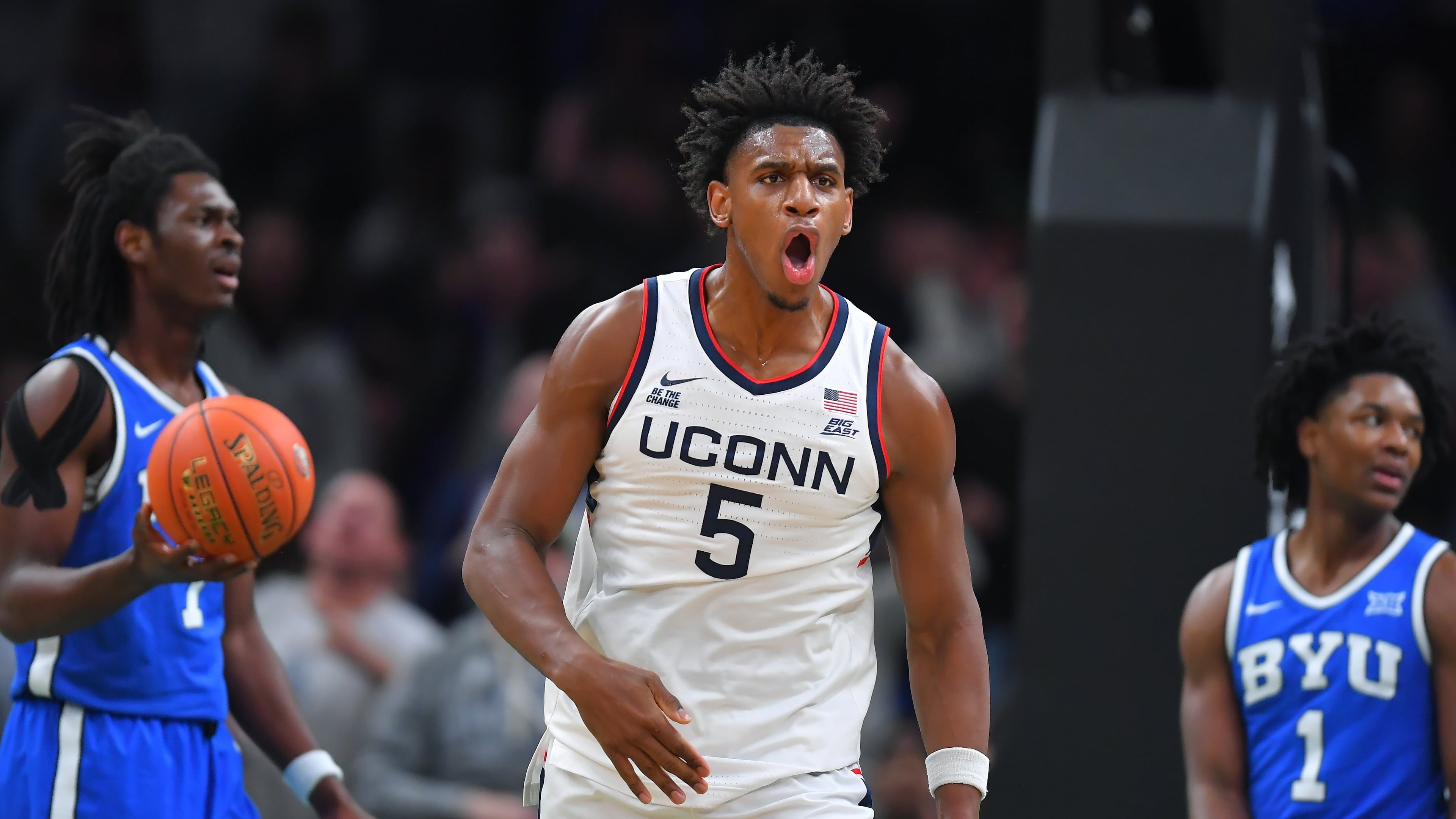 UConn forward Tarris Reed Jr., center, celebrates in front of BYU forward Khadim Mboup, left, and guard Robert Wright III after scoring in the first half of an NCAA college basketball game, Saturday, Nov. 15, 2025, in Boston. (AP Photo/Steven Senne)
