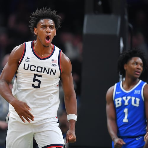 UConn forward Tarris Reed Jr., center, celebrates in front of BYU forward Khadim Mboup, left, and guard Robert Wright III after scoring in the first half of an NCAA college basketball game, Saturday, Nov. 15, 2025, in Boston. (AP Photo/Steven Senne)