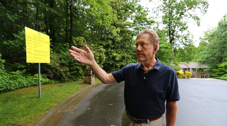 Michael Hartley stands beside the property his neighbor is trying to sell next door to his home on a cul-de-sac where a developer hopes to add around 20 new homes on Tuesday, May 23, 2017, in Roswell. Curtis Compton/ccompton@ajc.com