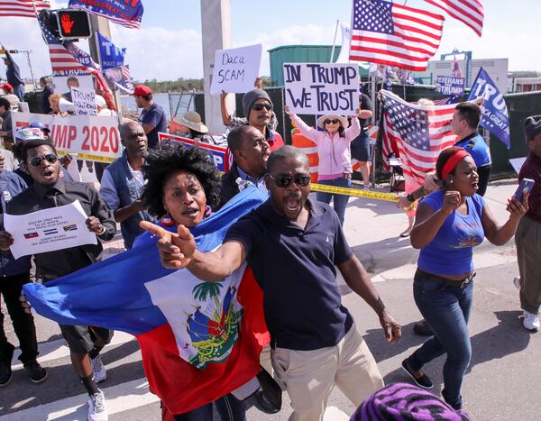 Haitian community members show up in large numbers at the Southern Blvd. bridge in West Palm Beach Monday, January 15, 2018 to protest recent remarks made by President Donald Trump against Haiti. The group said they were there to demand an apology from the President.  Damon Higgins / The Palm Beach Post