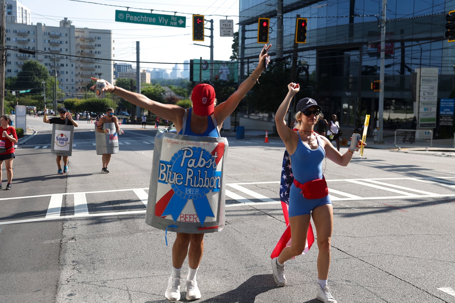 Participants wear beer inspired costumes as they go up "Cardiac Hill" during the 56th running of the Atlanta Journal-Constitution Peachtree Road Race in Atlanta on Friday, July 4, 2025.   (Abbey Cutrer / AJC)