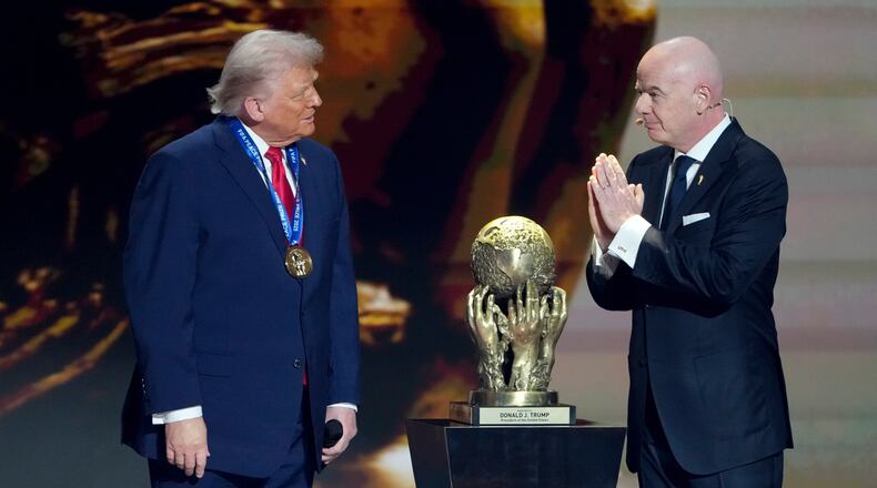FIFA President Gianni Infantino, right, awards President Donald Trump with the FIFA Peace Prize during the draw for the 2026 soccer World Cup at the Kennedy Center in Washington, Friday, Dec. 5, 2025. (AP Photo/Chris Carlson)