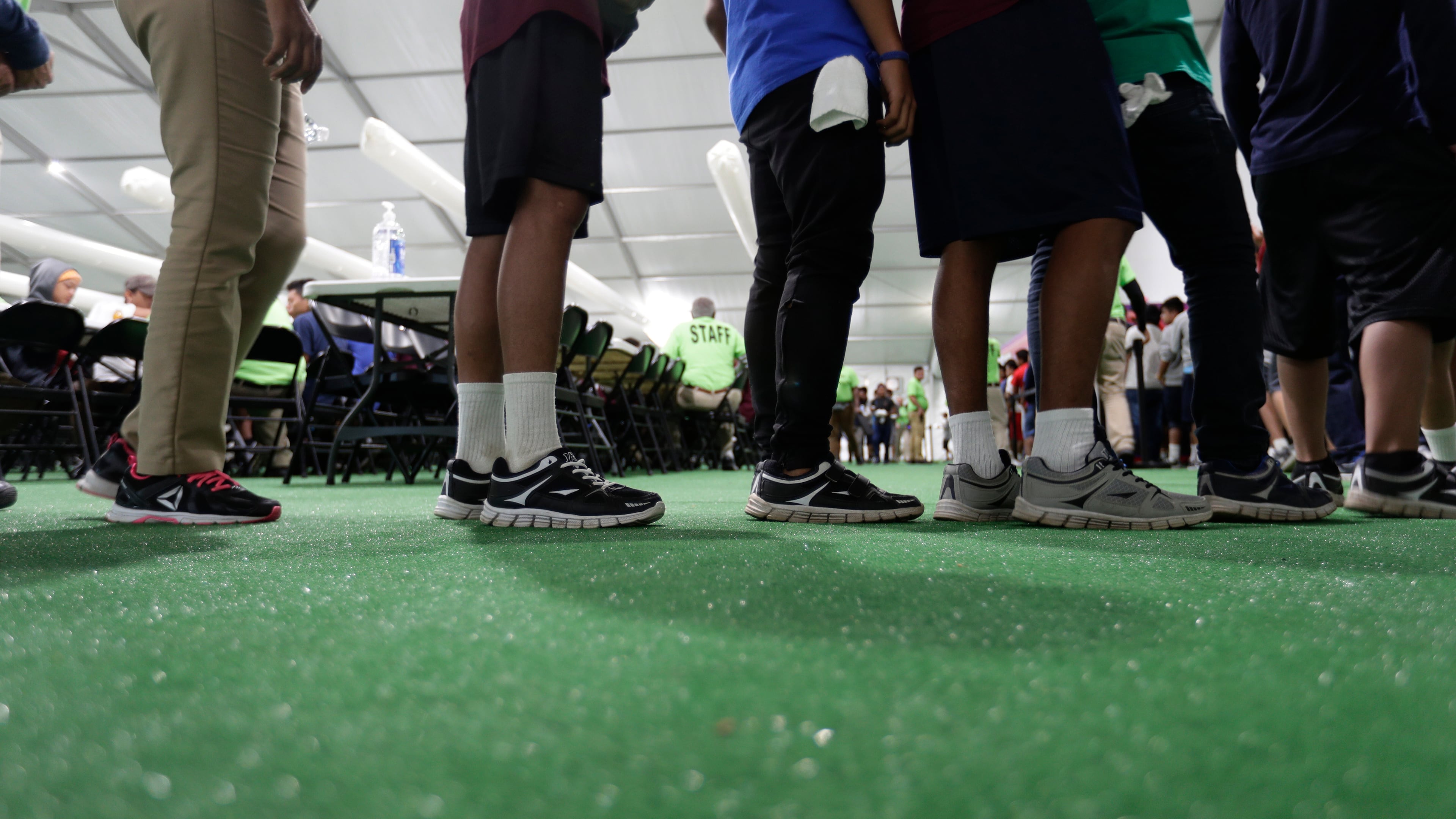 FILE - Immigrants line up in the dining hall at a new U.S. government holding center for migrant children in Carrizo Springs, Texas, on July 9, 2019. (AP Photo/Eric Gay, File)