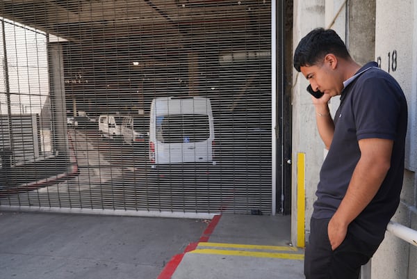 Alejandro Barranco talks on his cell phone outside the Metropolitan Detention Center, where is father Narciso is detained, on Monday, June 23, 2025, in Los Angeles. (AP Photo/Damian Dovarganes)
