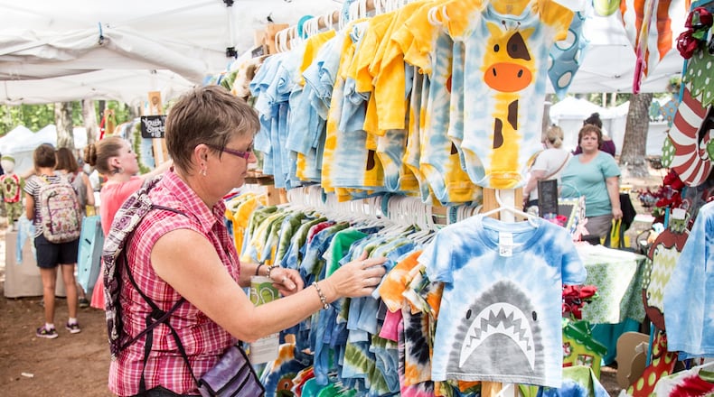Pat Asay looks through children’s clothes at the Yellow Daisy Festival in Stone Mountain Park on September 10, 2016. STEVE SCHAEFER / SPECIAL TO THE AJC