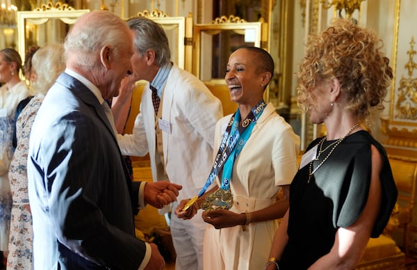 Britain's King Charles III speaks with broadcaster Adele Roberts during a reception in Buckingham Palace, London, in celebration of community-based initiatives raising awareness about cancer and supporting those living with cancer, Wednesday April 30, 2025. (Andrew Matthews/Pool Photo via AP)