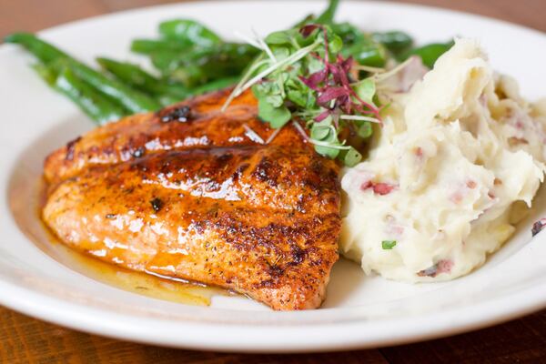 One of the entrees at Old Lady Gang is Kandi’s Glazed Blackened Salmon with red mashed potatoes and Mama Joyce’s green beans. It’s named for owner Kandi Burruss, one of the stars of “Real Housewives of Atlanta.” CONTRIBUTED BY HENRI HOLLIS