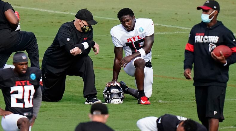 Coach Dan Quinn chats with receiver Brandon Powell during Wednesday's workout in Flowery Branch. (AP Photo/Brynn Anderson, Pool)