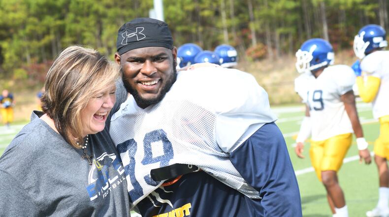 Stephanie Scott (left) greets football player Kareem Warren (right) at Reinhardt University.