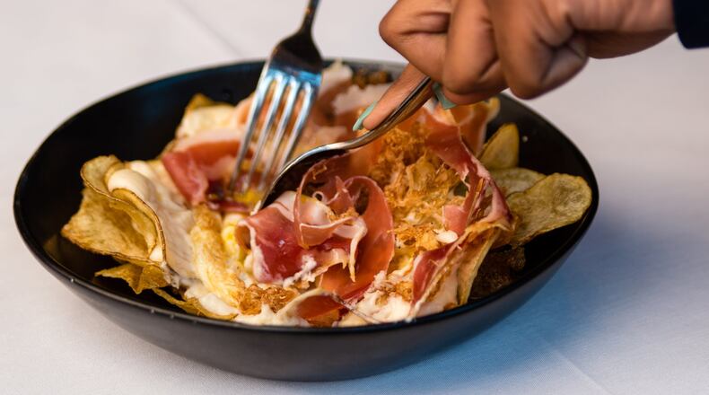 Huevos Bulla is a dish of eggs, house-made potato chips and serrano ham that is mixed tableside. CONTRIBUTED BY HENRI HOLLIS