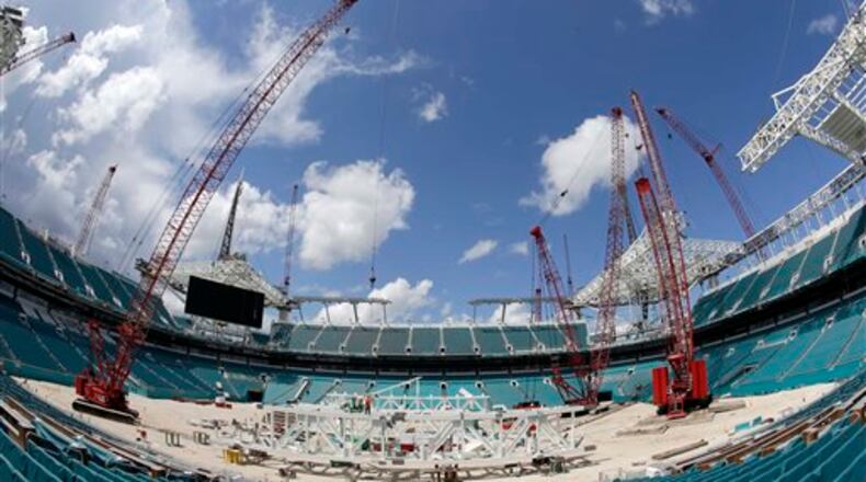 Workers assemble trusses in the center of the field that will support a 530,000-square-foot canopy at the Miami Dolphins' NFL football stadium, Thursday, June 2, 2016, in Miami Gardens, Fla. The first game of 2016 is three months away, and the stadium is far from ready. But Dolphins officials say they're on schedule with a major renovation, thanks to crews working around the clock since late December, which has pushed the cost to $500 million. (AP Photo/Alan Diaz)