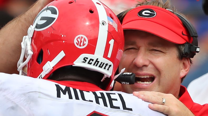 A little happiness is a good thing - here Georgia head coach Kirby Smart congratulates Sony Michel on his 50-yard touchdown run against Vandy Saturday. Just don't get carried away. (Curtis Compton/Atlanta Journal-Constitution/TNS)