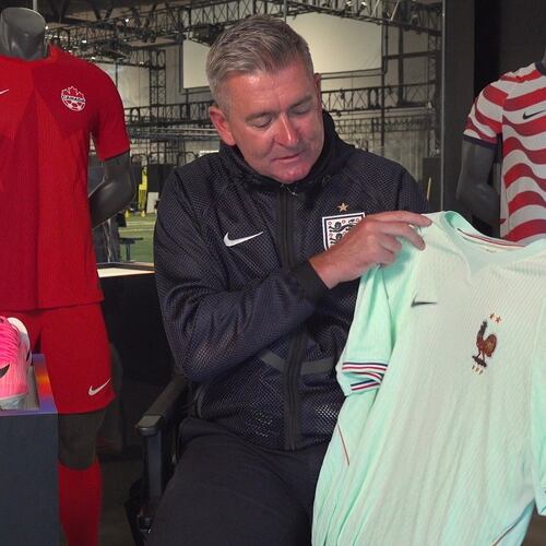 Phil McCartney, chief innovation, design and product officer for Nike, holds up the away jersey for France that the company designed for the World Cup during an interview at Nike headquarters in Beaverton, Ore., on June 22, 2026. (AP Photo/Claire Rush)